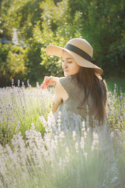 Beautiful young woman on lavender field. Sunset. Attractive young female outdoors.