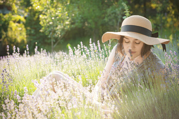 Beautiful young woman on lavender field. Sunset. Attractive young female outdoors.