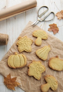 Sonbahar pastası. Balkabağı şeklinde kurabiyeler ve masada yapraklar. Samimi sonbahar konsepti.