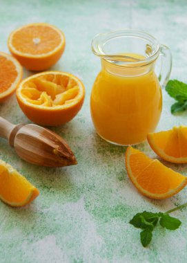 Glass jug of fresh orange juice with fresh fruits