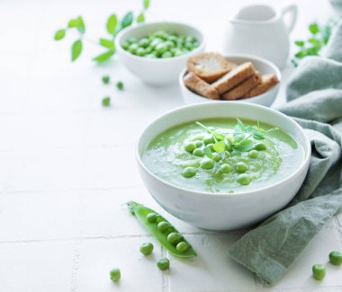 Beyaz fayanslı taze bezelye çorbası kasesi.