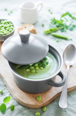 Fresh green pea soup bowl on gray concrete background
