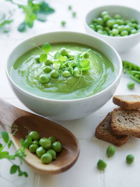 Beyaz fayanslı taze bezelye çorbası kasesi.