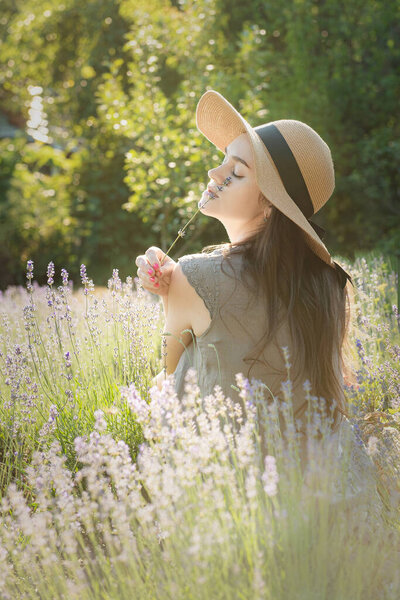 Beautiful young woman on lavender field. Sunset. Attractive young female outdoors.