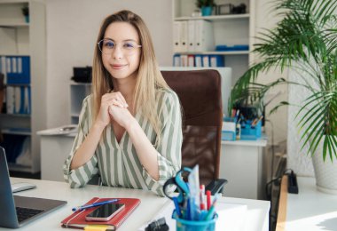 Ofisindeki bilgisayarda çalışan genç bir kadın.