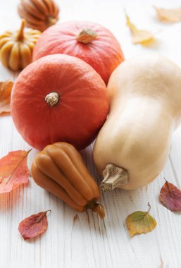 Ahşap arka planda güz yaprakları olan sonbahar dekoratif balkabakları. Şükran Günü ya da Cadılar Bayramı bayramı, hasat konsepti.