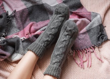 Samimi örgü çoraplı genç bir kızın bacakları. Ekose çorap giymiş kadın bacakları. Isınma mevsimi kavramı