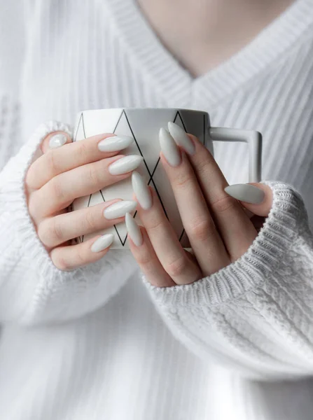 Piękne Dłonie Młodej Kobiety Białym Manicure Paznokciach Dziewczyna Swetrze Trzyma — Zdjęcie stockowe