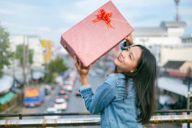 Mutlu genç kızlar şehrin arka planında Noel şapkası takarlar..