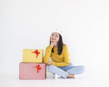 Mutlu genç kız hediye kutusunu tut, Asyalı kız beyaz arka planda sarı kazak giy.