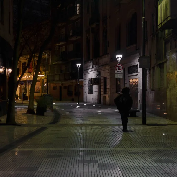 Night walker through an illuminated passage