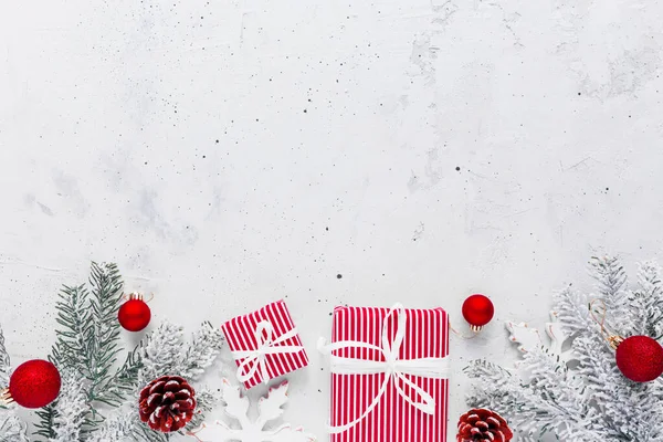 Noel, yeni yıl gri beton dairesi kırmızı beyaz hediye kutularıyla üst manzaralı. Hediye kurdelesi ve ambalaj kağıdı. Noel ağacı köknarı, koniler, oyuncaklar. Yüksek kaliteli fotoğraf üzerine uzay metin alanını kopyala