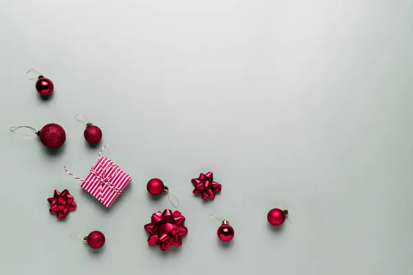 Grauer Hintergrund Mit Rosa Weihnachtsgeschenkschachtel Kleinen Roten Weihnachtskugeln Oder Kugelspielzeug — Stockfoto