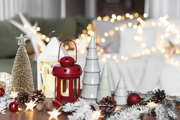 様々な家庭の装飾とクリスマスや新年の組成物は 異なる象徴的なおもちゃが構成され ソファの白いカバーで背景にぼやけたクリスマスライトとコーヒーテーブルで注文しました 家族の時間 — ストック写真
