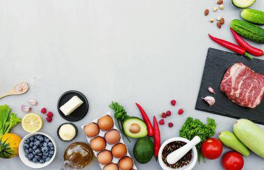 Farklı yiyecekler, pirzola ya da sığır filetosu bifteği, organik sebzeler, biyolojik meyveler, böğürtlen, fındık, baharat, bitki, zeytinyağı, yumurta. Bir metin için alanı kopyala. Gri beton arkaplan