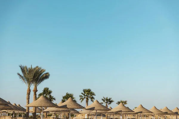 Соломенный зонтик или соломенная хижина с прекрасным видом на небо на тропический пляж — стоковое фото
