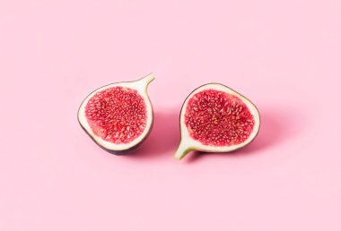 Taze lezzetli incir meyveleri. Pembe arka planda gölgeler var.