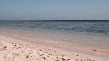 Küçük bir kız sevinçle koşar deniz boyunca Kızıl Deniz kıyısında kumların üzerinde