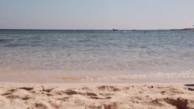 Küçük bir kız sevinçle koşar deniz boyunca Kızıl Deniz kıyısında kumların üzerinde