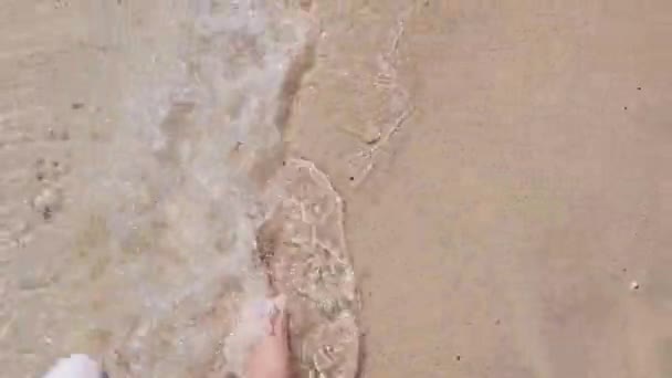 Jeune femme jambes sur une plage de sable, vague laver les jambes de marche — Video