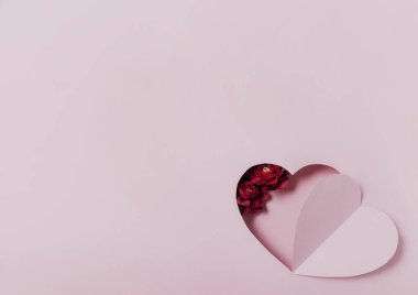 Aşk mesajı mı yoksa Sevgililer Günü dairesi mi? Pembe kağıt kalp kartı, çiçekler.
