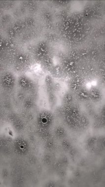 Otomatik yıkama sırasında cam üzerindeki şeffaf köpük kabarcıkları araba camına akar.