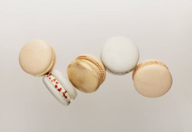 Beyaz, sarı, altın renkli kurabiyeler uçuyor, hareket halinde düşüyor ya da havada uçuyor.