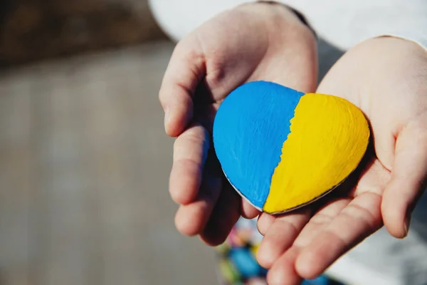 우크라이나 국기나 국가가 새겨진 하트 모양의 돌을 들고 있는 작은 아이 — 스톡 사진