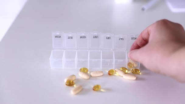 Mano poner pastillas a la caja de la píldora médica, dosis de tabletas para la toma diaria, medicamentos, cápsulas — Vídeos de Stock