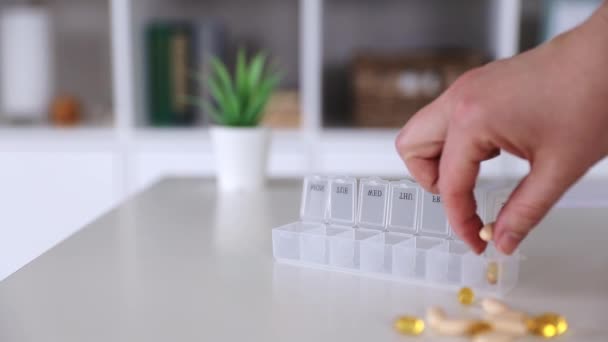 Main mettre des pilules dans la boîte à pilules médicales, doses de comprimés pour la prise quotidienne, médicaments, capsules — Video