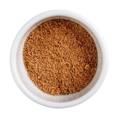 Yerdeki hindistan cevizi beyaza izole edilmiş. Beyaz kasede taze rendelenmiş baharat. Yakın çekim, üst görünüm.