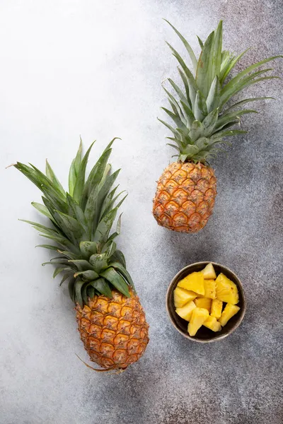 Two Whole Fresh Ripe Pineapples Bowl Chopped Pineapple Concrete Background — Stock Photo, Image