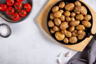 Beton zeminde, dökme demir tavada bütün patatesleri kızarttım. Üst manzara, kopyalama alanı, yemek arkaplanı. Vejetaryen ya da vejetaryen gıda konsepti.