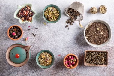 Seramik kaselerde kurutulmuş çay çeşitleri. Siyah, yeşil ve bitkisel çay koleksiyonları. Üst görünüm, boşluğu kopyala. Gıda arkaplanı.