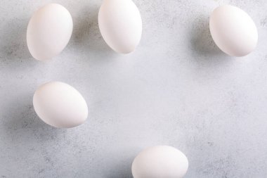 White chicken eggs on concrete background. Food background. Top view, copy space.
