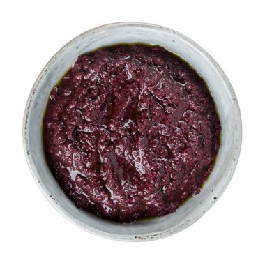 Tapenade, siyah zeytinlerden yapılmış zeytin ezmesi. Beyaza izole edilmiş kasede yayılabilir siyah zeytinyağı. Üst görünüm.