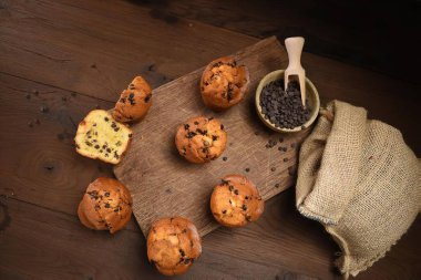 Koyu ahşap arka planda çikolatalı kremalı kekler.