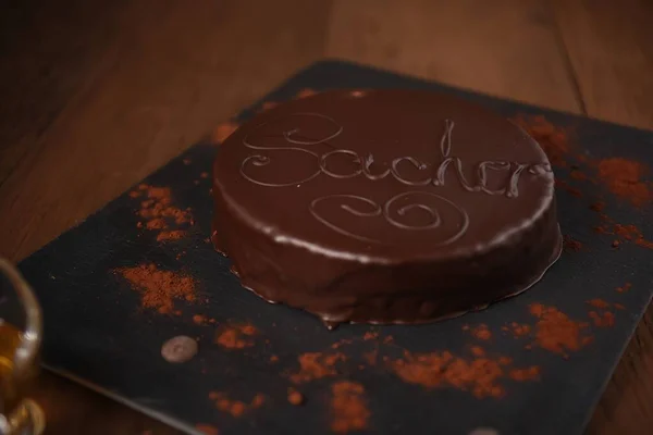 Ahşap arka planda Sacher kremalı keki
