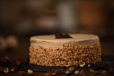 Tahta arka planda fındıklı lezzetli kremalı pasta.