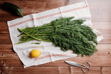 Ahşap bir masanın üzerinde, mutfak örtüsünün üzerinde bir sürü taze dildo..