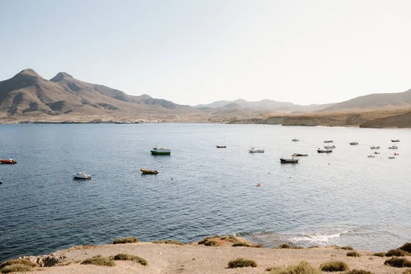 Güneşli bir yaz gününde arka planda deniz manzarası, botlar, dağlar. Los Escullos, Cabo de Gata, Almerya, İspanya.