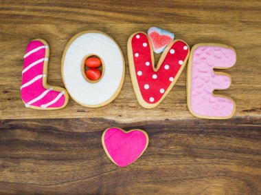 Aşk kelimesi ahşap masada ev yapımı kurabiyelerle yazılıyor.