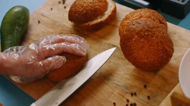 Порежь хлеб для бургера. Приготовьте бублик с копченым лососином. 4k видео — стоковое видео