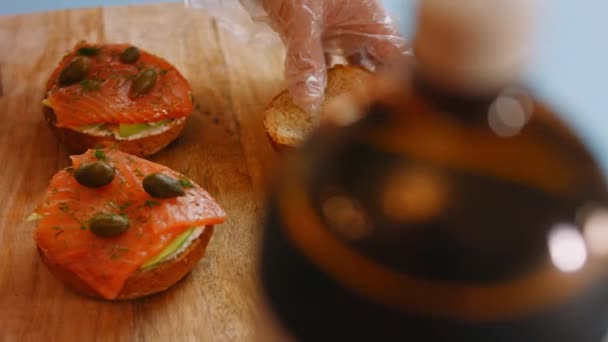 Aku meletakkan bagian atas roti pada mempersiapkan Salmon Bagel asap. Video 4k — Stok Video