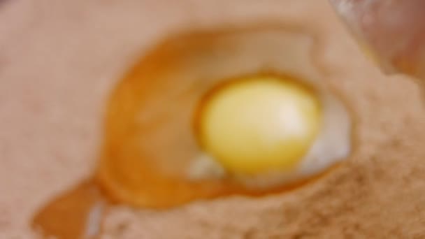 Ich breche ein Ei und füge es zu den Zutaten des Schokoladenkuchens hinzu. 4k-Video — Stockvideo