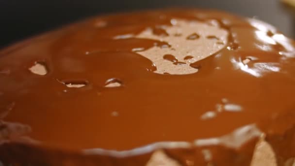 Versare il cioccolato fuso sulla torta al cioccolato. 4k video — Video Stock