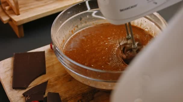 Mescolo gli ingredienti per la torta al cioccolato con il mixer. 4k video — Video Stock