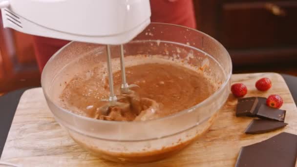 Misturo os ingredientes para o bolo de chocolate com a batedeira. 4k vídeo — Vídeo de Stock