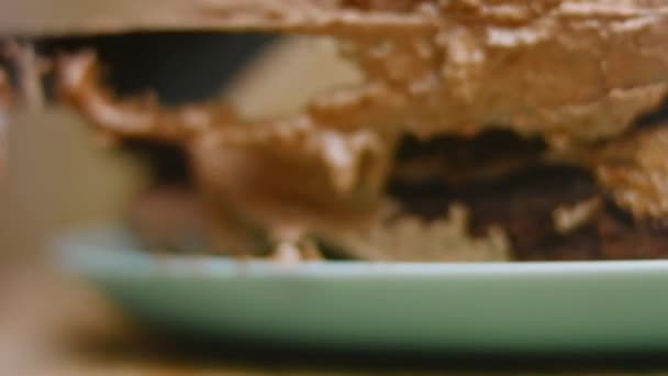 チョコレートケーキから生地をヌテッラでグリースします。4kビデオ — ストック動画