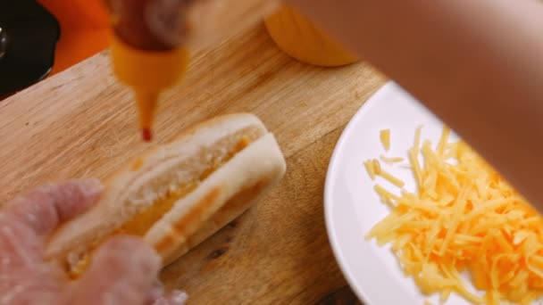 Tillsätt ketchup till varmkorven. 4k-video — Stockvideo